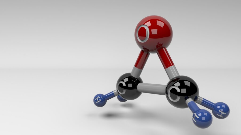 A model of an Ethylene Oxide molecule depicted in high-gloss red, black, and blue.
